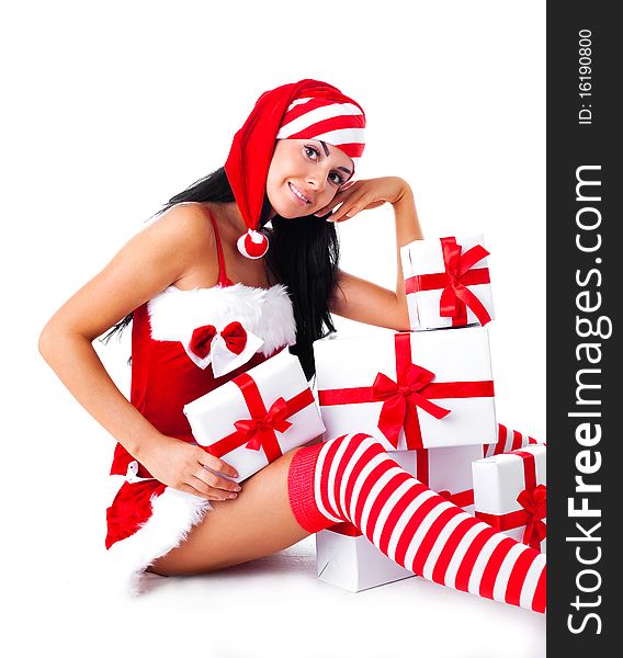 Beautiful young brunette woman dressed as Santa sitting on the floor with a lot of presents. Beautiful young brunette woman dressed as Santa sitting on the floor with a lot of presents