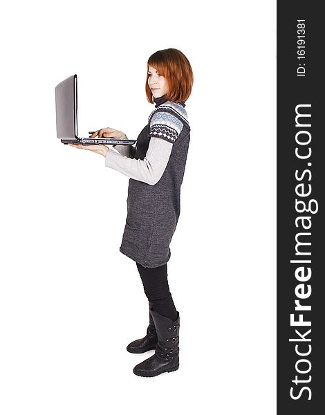 Girl in knit dress standing with laptop