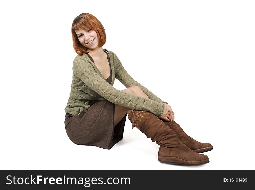 Young beautiful girl in brown skirt sitting and smiling, isolated on white