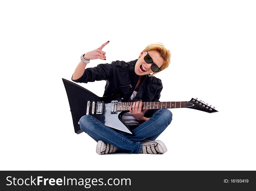 Passionate rock girl playing an electric guitar seated and making a rock gesture. Passionate rock girl playing an electric guitar seated and making a rock gesture