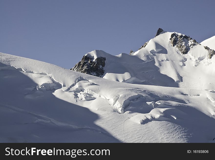 From the top of l'Aiguille du Midi (3842 m), the views of the Alps are spectacular. In this picture you can see one of the paths that lead to the summit of Mont-Blanc. Top right, you can see the Mont Maudit, near the Mont-Blanc, seen from l'Aiguille du Midi. From the top of l'Aiguille du Midi (3842 m), the views of the Alps are spectacular. In this picture you can see one of the paths that lead to the summit of Mont-Blanc. Top right, you can see the Mont Maudit, near the Mont-Blanc, seen from l'Aiguille du Midi.