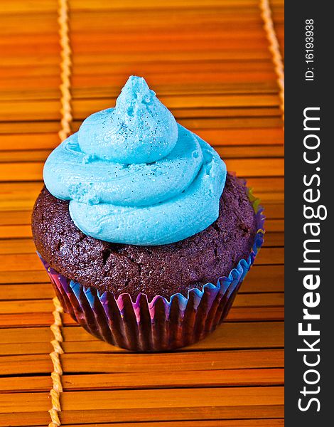 Blue vanilla cupcake over a bamboo table place mats