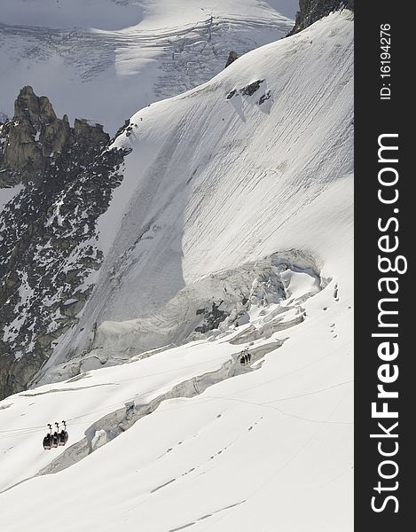 From the summit of l'Aiguille du Midi (3,842 m), the views of the Alps are spectacular. In this picture, you can see the panoramic funicular leading to a peak in Italy. From the summit of l'Aiguille du Midi (3,842 m), the views of the Alps are spectacular. In this picture, you can see the panoramic funicular leading to a peak in Italy