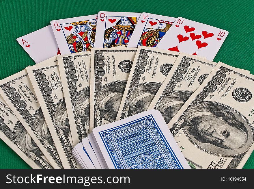 Poker cards showing royal flush and dollars on green cloth