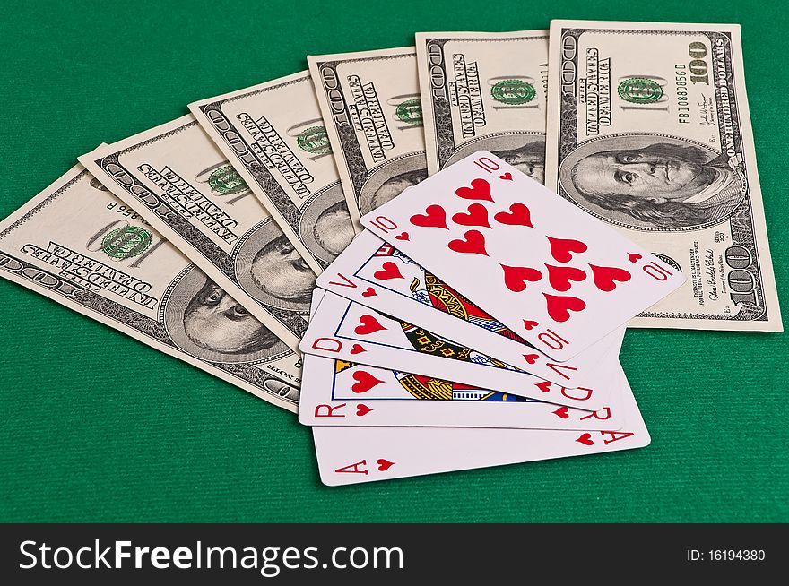 Poker cards showing royal flush and dollars on green cloth