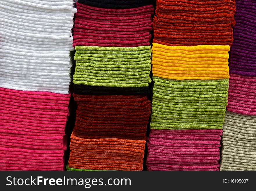 Towels of many colors are stacked atop each other, on display at the Otavalo MarketPlace in Ecuador, the largest indigenious marketplace in the world. Towels fill the frame and can be used for a horizontal design background. Towels of many colors are stacked atop each other, on display at the Otavalo MarketPlace in Ecuador, the largest indigenious marketplace in the world. Towels fill the frame and can be used for a horizontal design background.