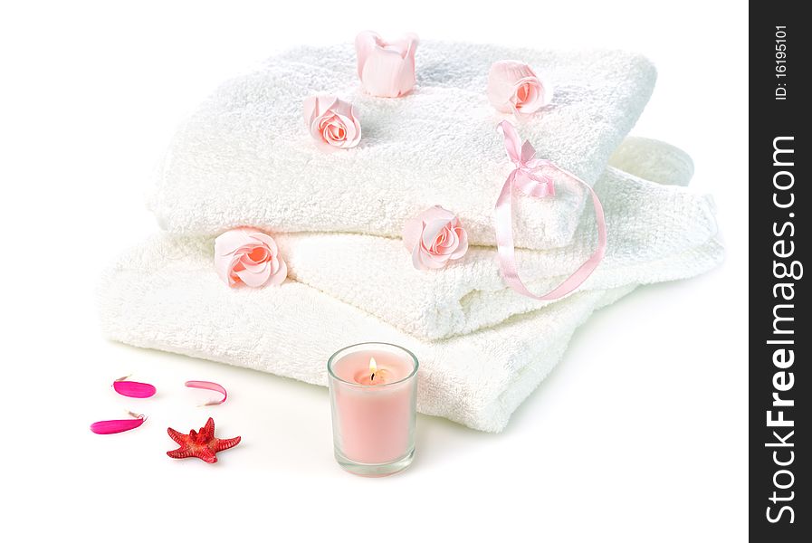 White towels with pink soap roses and candle on white background. White towels with pink soap roses and candle on white background