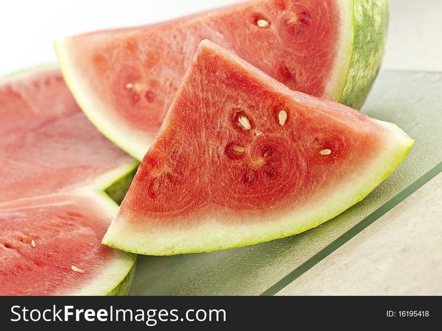 Fresh cut juicy watermelon on a cutting board with white background. Fresh cut juicy watermelon on a cutting board with white background