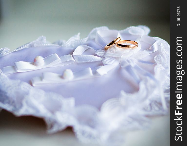 Gold wedding rings on the white pincushion