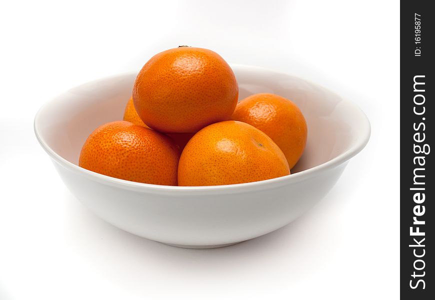 White ceramic bowl with orange mandarines. White ceramic bowl with orange mandarines.