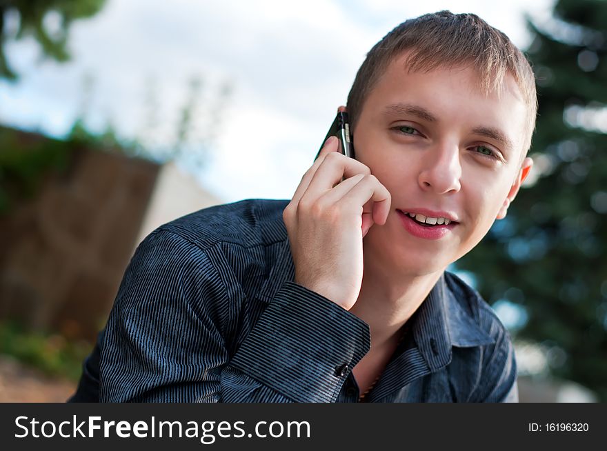 Smiling guy talking on cellphone
