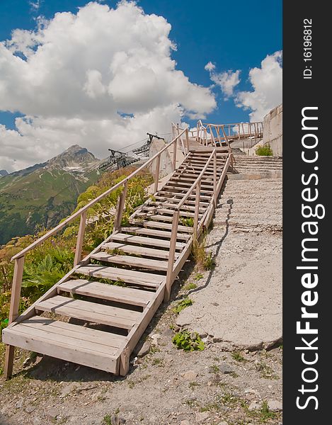 Crooked wooden staircase leading up mountains in the background. Crooked wooden staircase leading up mountains in the background.