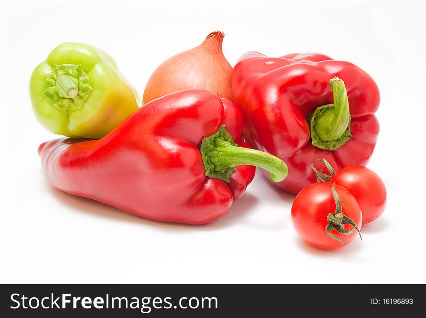 Fresh ripe red and green peppers with onion and cherry-tomatoes isolated on white background. Fresh ripe red and green peppers with onion and cherry-tomatoes isolated on white background