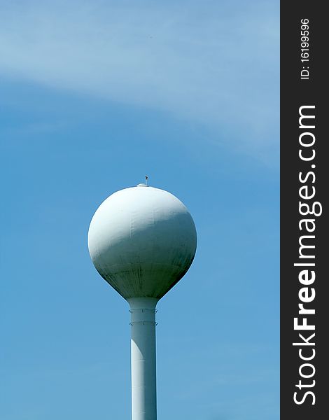 A white watertower against blue sky