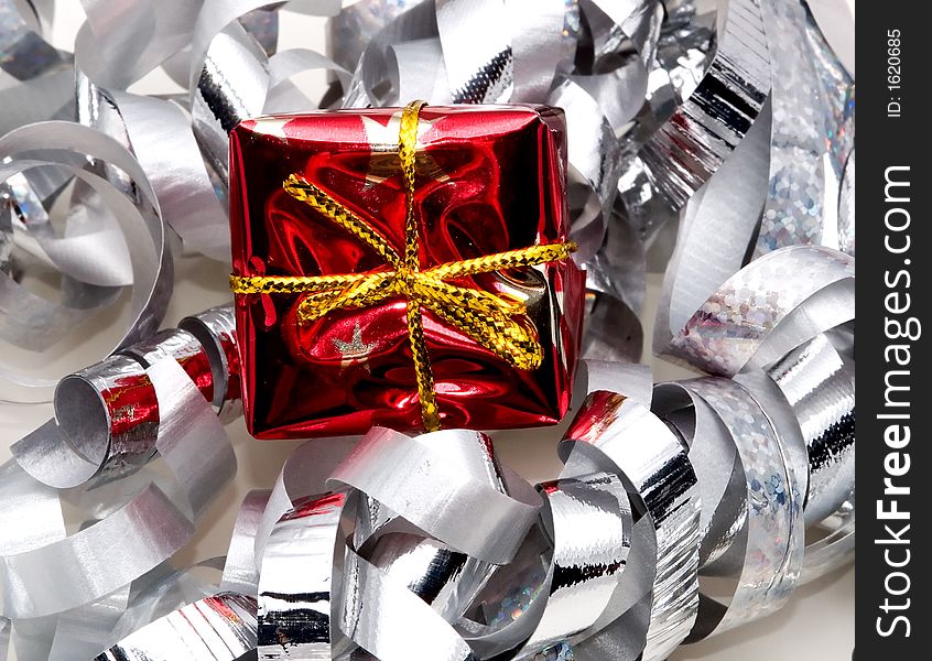 A holiday or birthday gift surrounded by silver ribbon. A holiday or birthday gift surrounded by silver ribbon