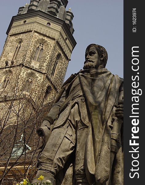 A statue on the central square of Bautzen with the tower of the ecumenical church in the background. A statue on the central square of Bautzen with the tower of the ecumenical church in the background