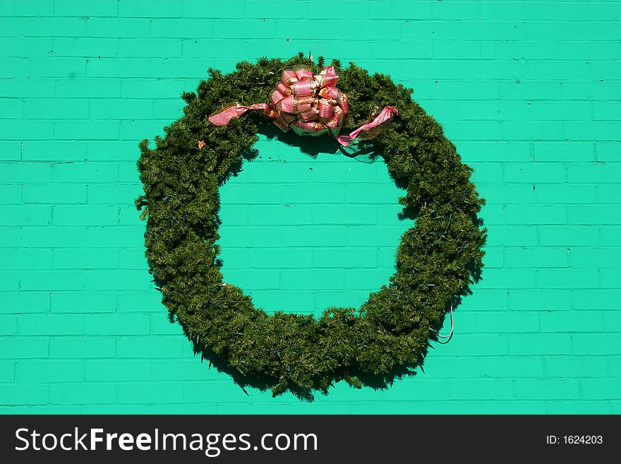 Christmas wreath hanging on green painted brick wall. Christmas wreath hanging on green painted brick wall