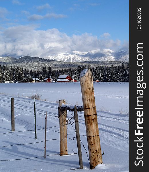 This image of the red farm house and red barn nestled in the snowcovered trees was taken in western MT. This image of the red farm house and red barn nestled in the snowcovered trees was taken in western MT.