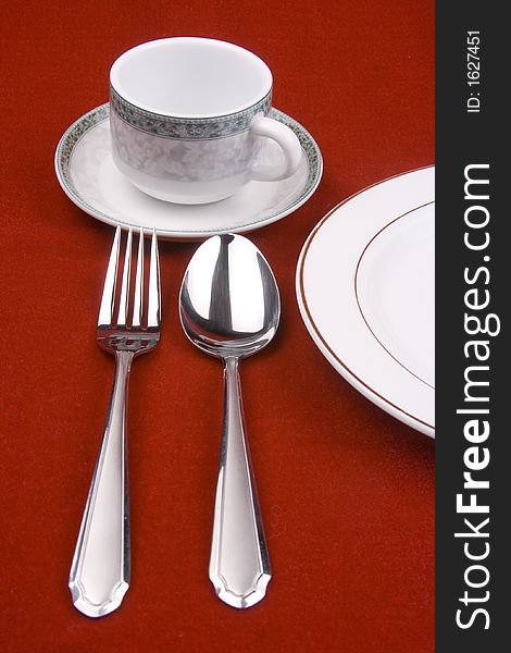 Place setting of a dinning set in red background.