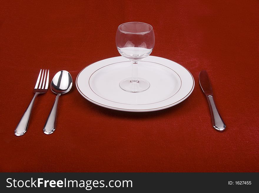 Place setting of a dinning set in red background.