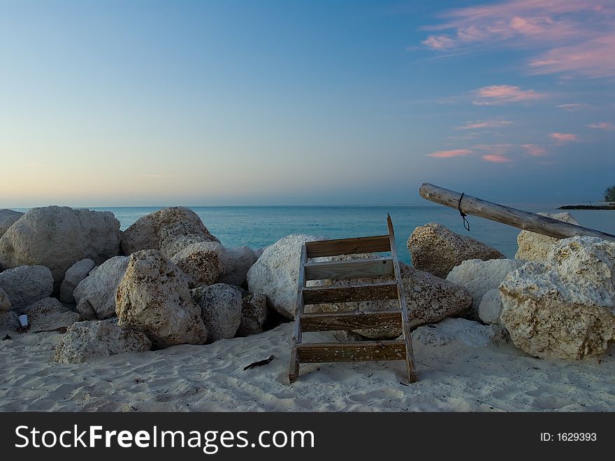 Old ladder leaning an rocks by ocean