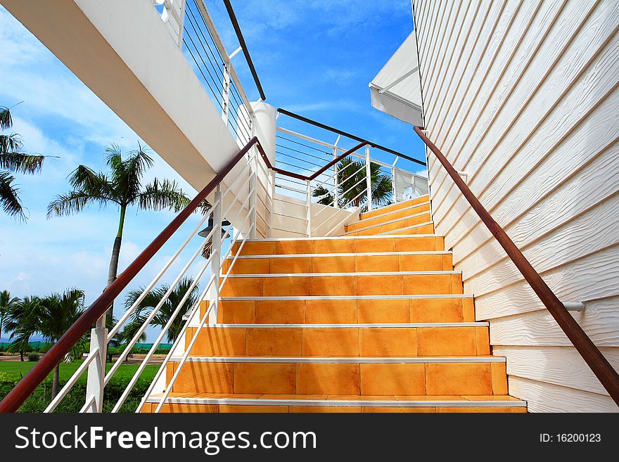 Orange staircase and white wooden wall