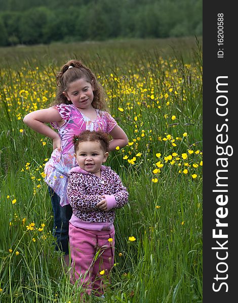 Two young girls playing around in a buttercup field. Two young girls playing around in a buttercup field