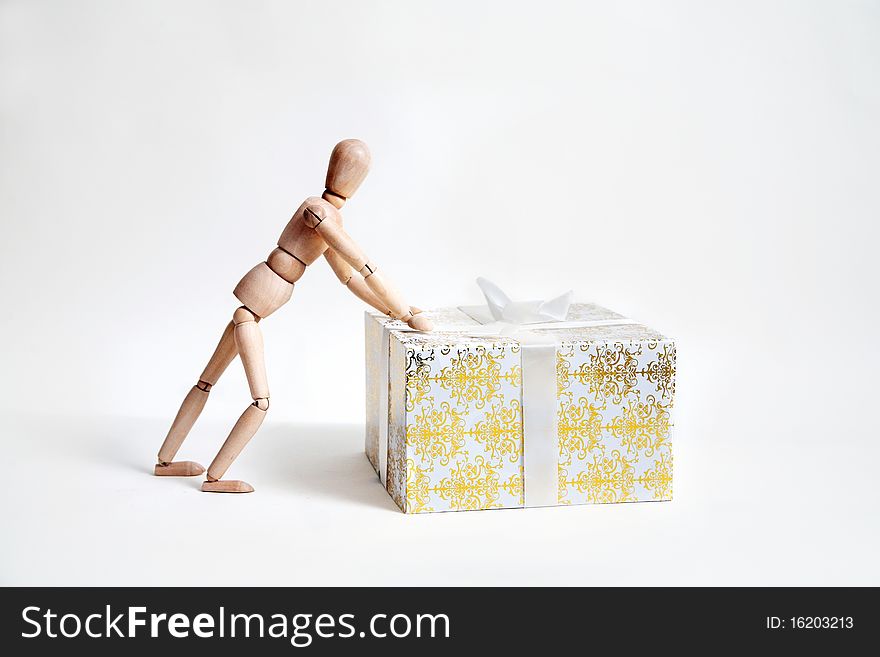 Wooden toy in the form of person withgift box isolated on white background