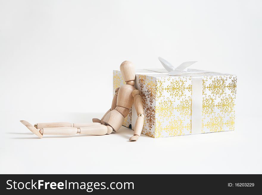 Wooden toy in the form of person withgift box isolated on white background