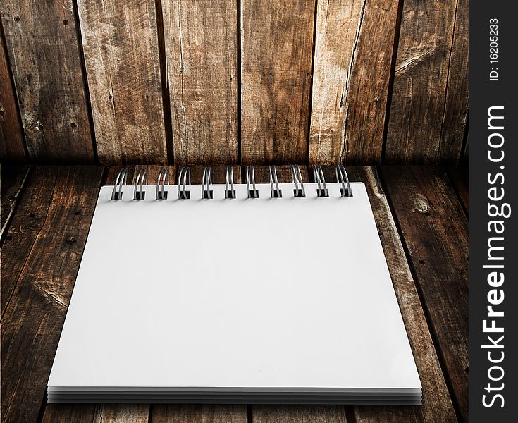 White notebook on wood floor