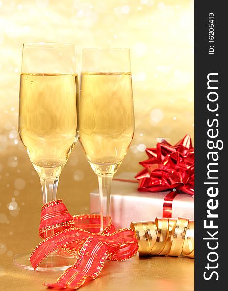 Studio photo of champagne glasses and golden and red decoration on background. Studio photo of champagne glasses and golden and red decoration on background