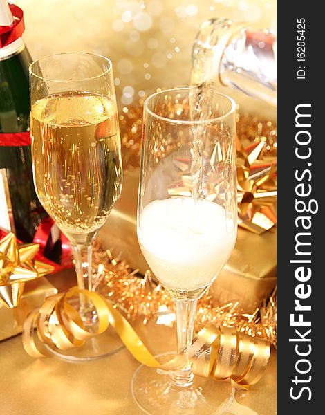 Studio photo of champagne glasses and golden and red decoration on background. Studio photo of champagne glasses and golden and red decoration on background