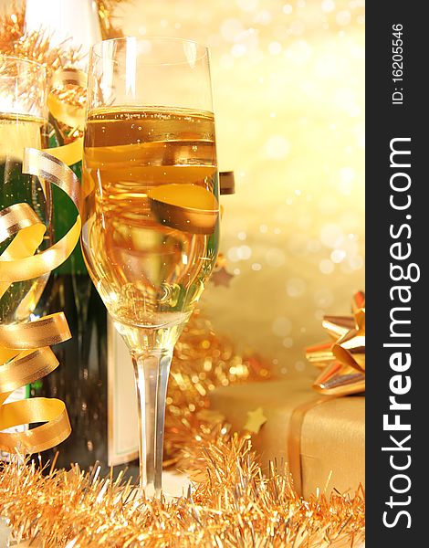 Studio photo of champagne glasses with bottle and golden decoration on background. Studio photo of champagne glasses with bottle and golden decoration on background