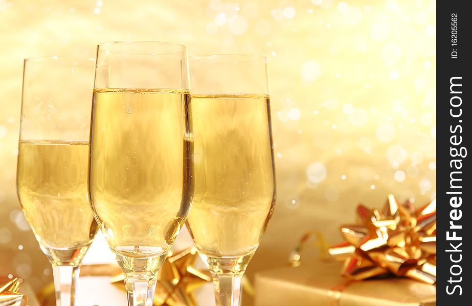 Studio photo of champagne glasses and golden decoration on background. Studio photo of champagne glasses and golden decoration on background