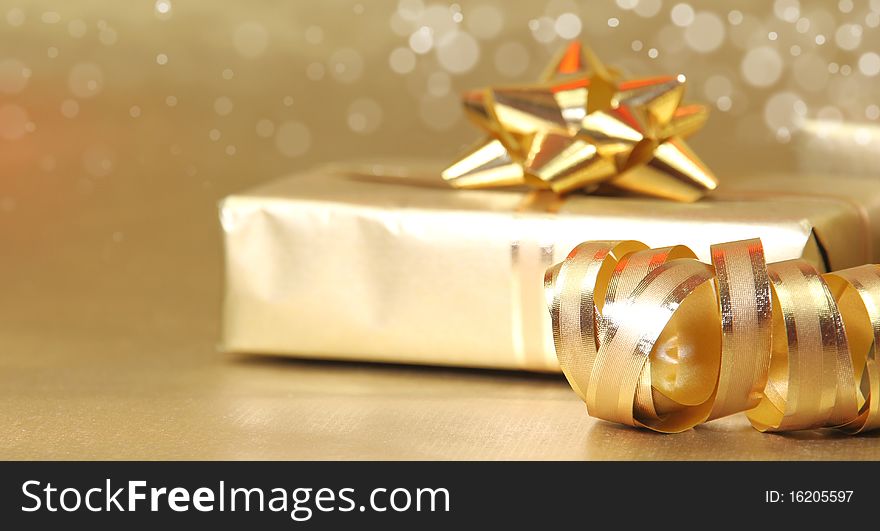 Studio photo of gold gift with decoration. Studio photo of gold gift with decoration