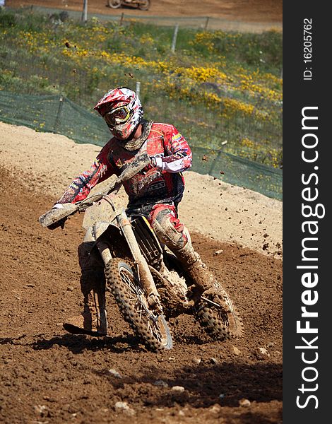 View of a motorcross dirtbike on the dirt performing a turn. View of a motorcross dirtbike on the dirt performing a turn.