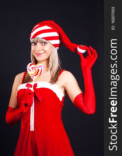 Santa girl holding a lollipop. Holidays New Year and Christmas
