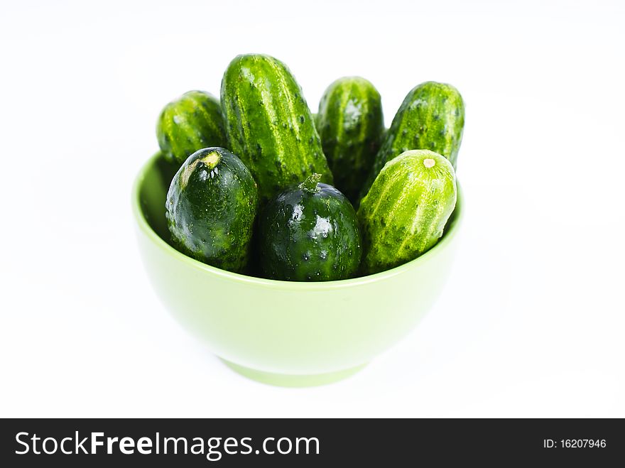 wet cucumbers in green bowl