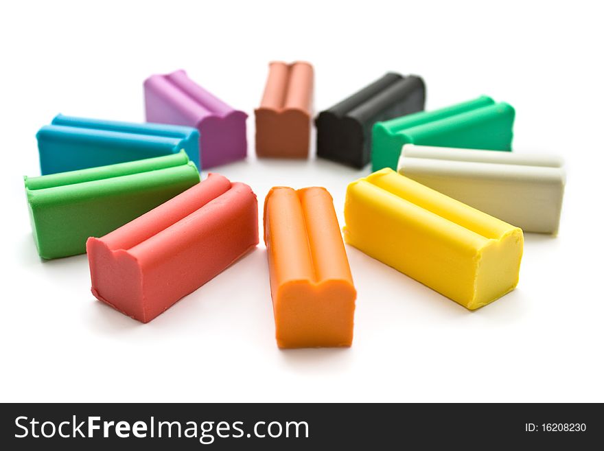 Multicolored plasticine with plastic knife on white