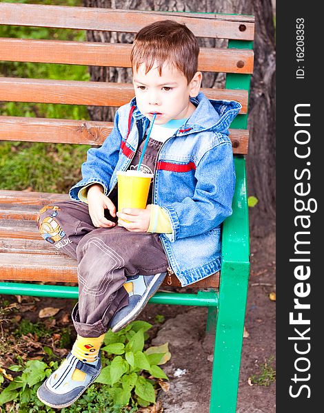 A little boy thinks and drinking with a glass tube. A little boy thinks and drinking with a glass tube