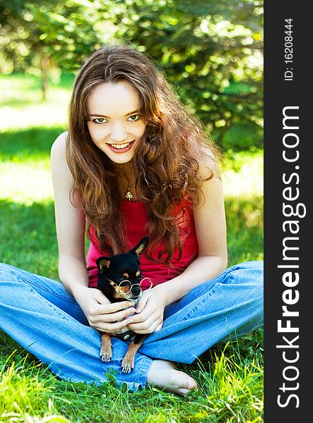 Teenager girl lying on the grass next to a Dog