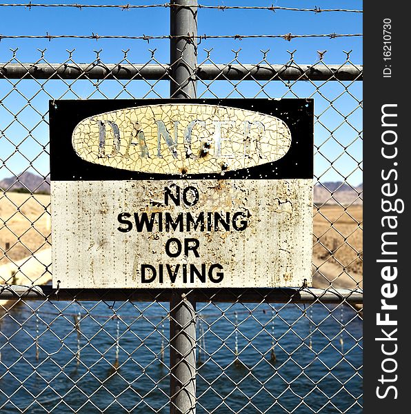 No swimming or diving sign in front of a canal. No swimming or diving sign in front of a canal
