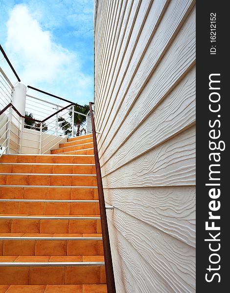 Orange staircase and white wooden wall