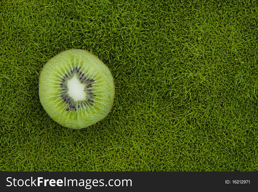 A kiwifruit on green grass background. A kiwifruit on green grass background