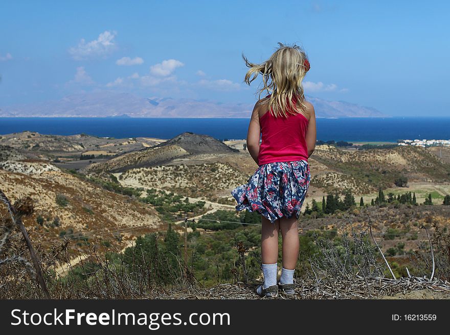 Girl looks at the sea, beach and mountains