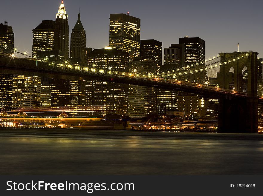 Downtown New York City Skyline and Brooklyn Bridge at dusk. Time Exposure with blurred motion. Downtown New York City Skyline and Brooklyn Bridge at dusk. Time Exposure with blurred motion.