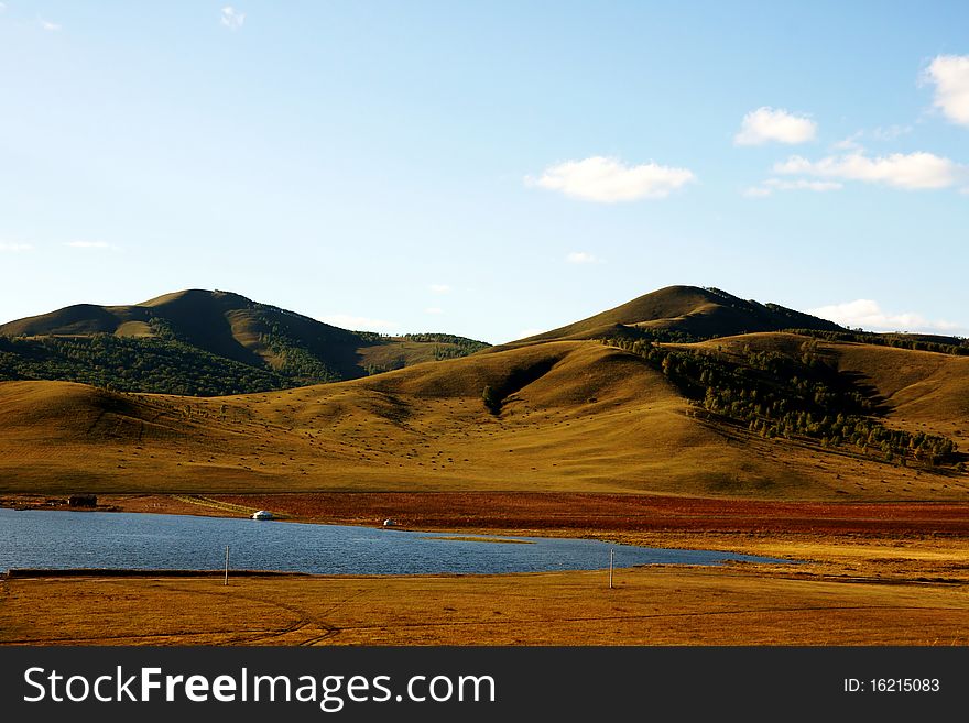 Grasslands; lakes and hills in the background blue sky. Grasslands; lakes and hills in the background blue sky