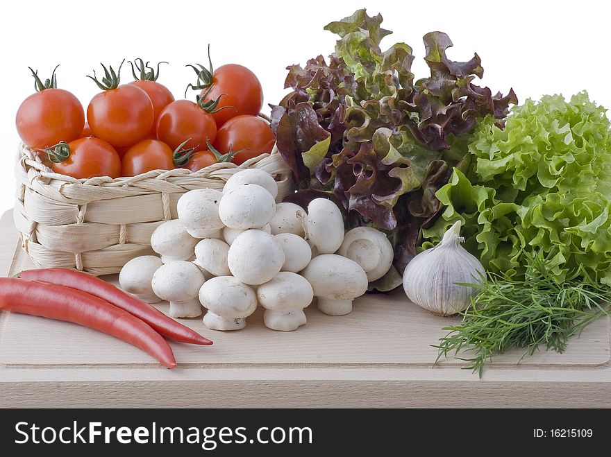 Fresh vegetables - salad, tomatos, red peppers, mushrooms, garlic and dill placed on chopping board