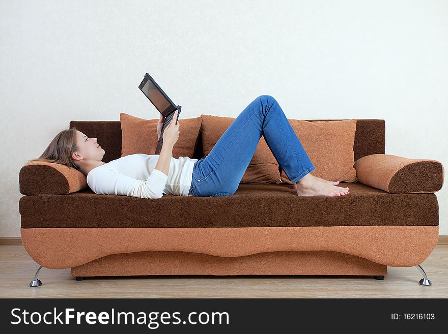 Young beatiful woman with laptop on the sofa