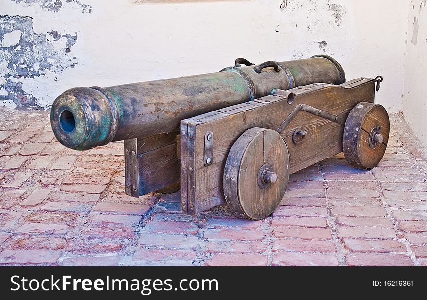 Ancient gun against a brick wall. Ancient gun against a brick wall